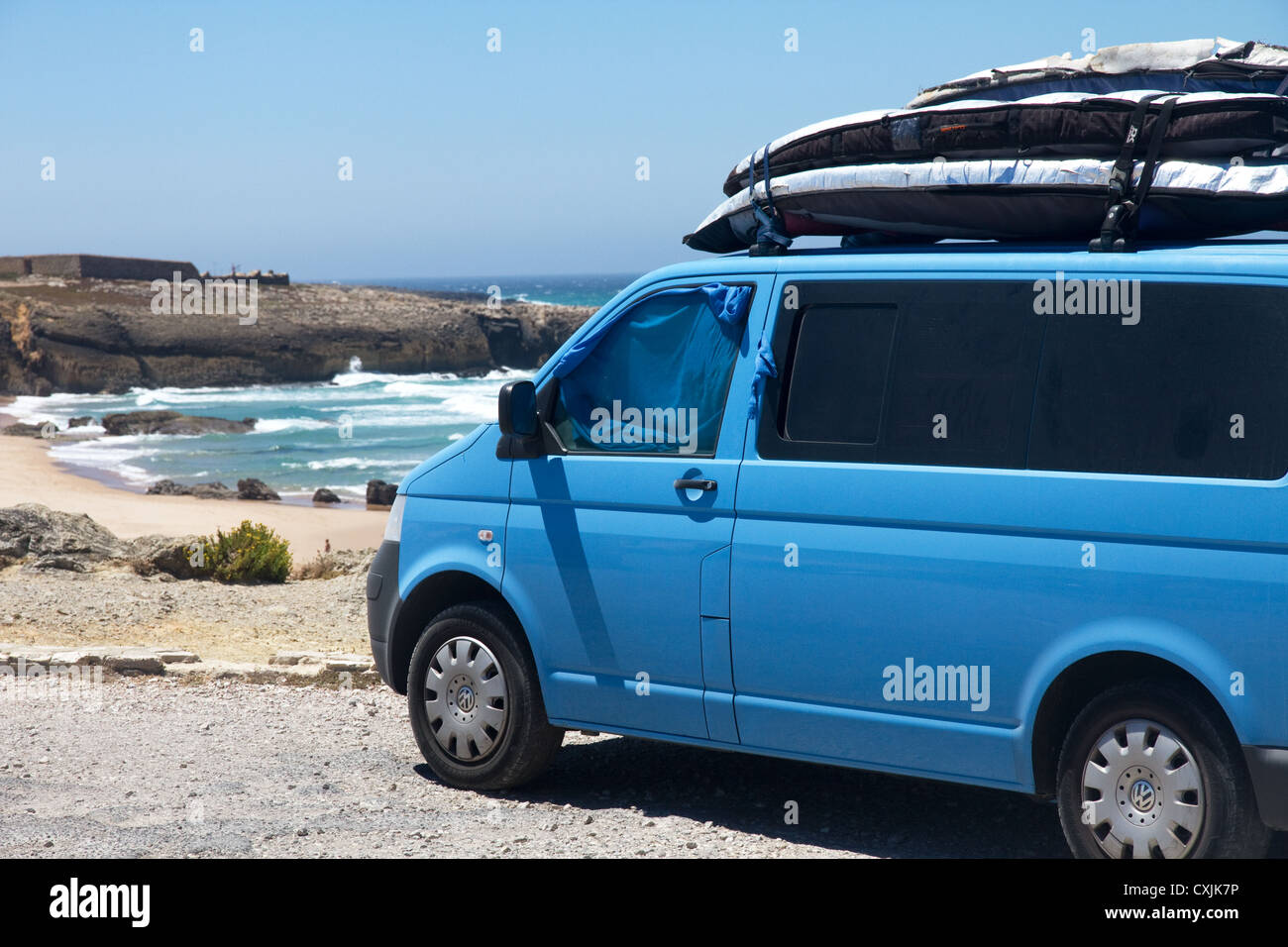 VW Camper e tavole da surf parcheggiato al di sopra di Praia da Cresmina (mostrato) e spiaggia di Guincho, Cascais, costa di Lisbona, Portogallo Foto Stock