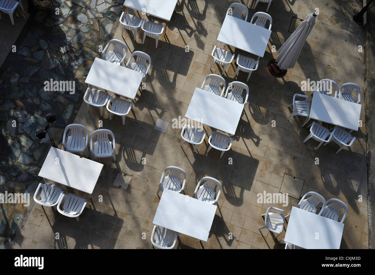 Dal - al di sopra di vista di tavoli e sedie bianchi impostato su una terrazza a Platres, Troodos, Cipro Foto Stock