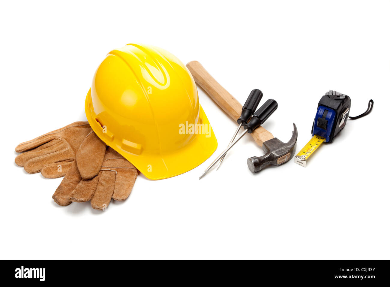 Hardhat giallo con guanti da lavoro e vari strumenti su sfondo bianco Foto Stock