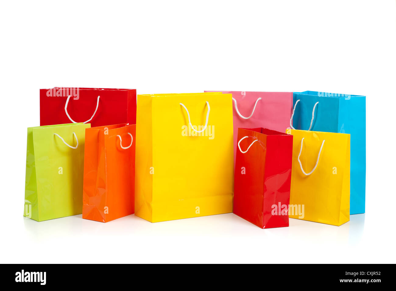 Fila di colori assortiti shopping bags su sfondo bianco Foto Stock