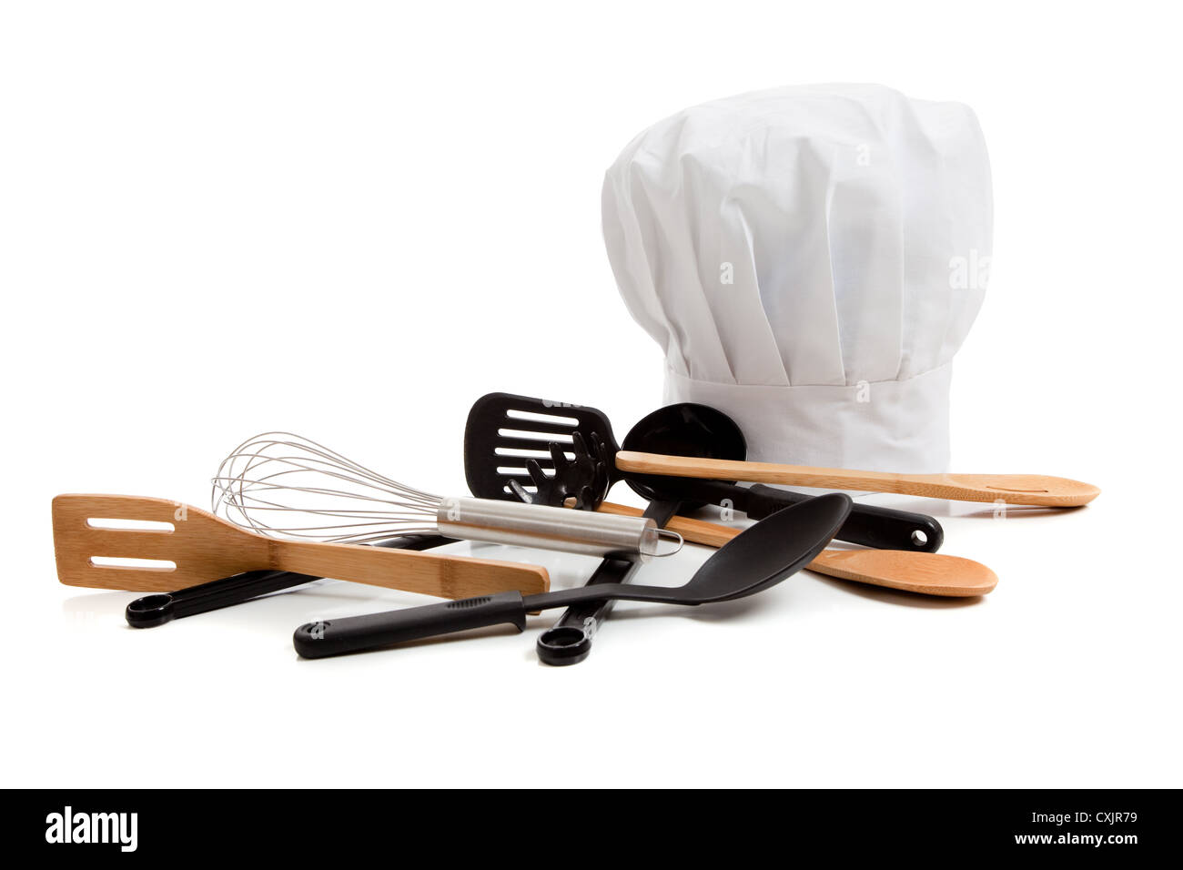 Lo chef del cappello con un assortimento di utensili di cottura su sfondo bianco Foto Stock