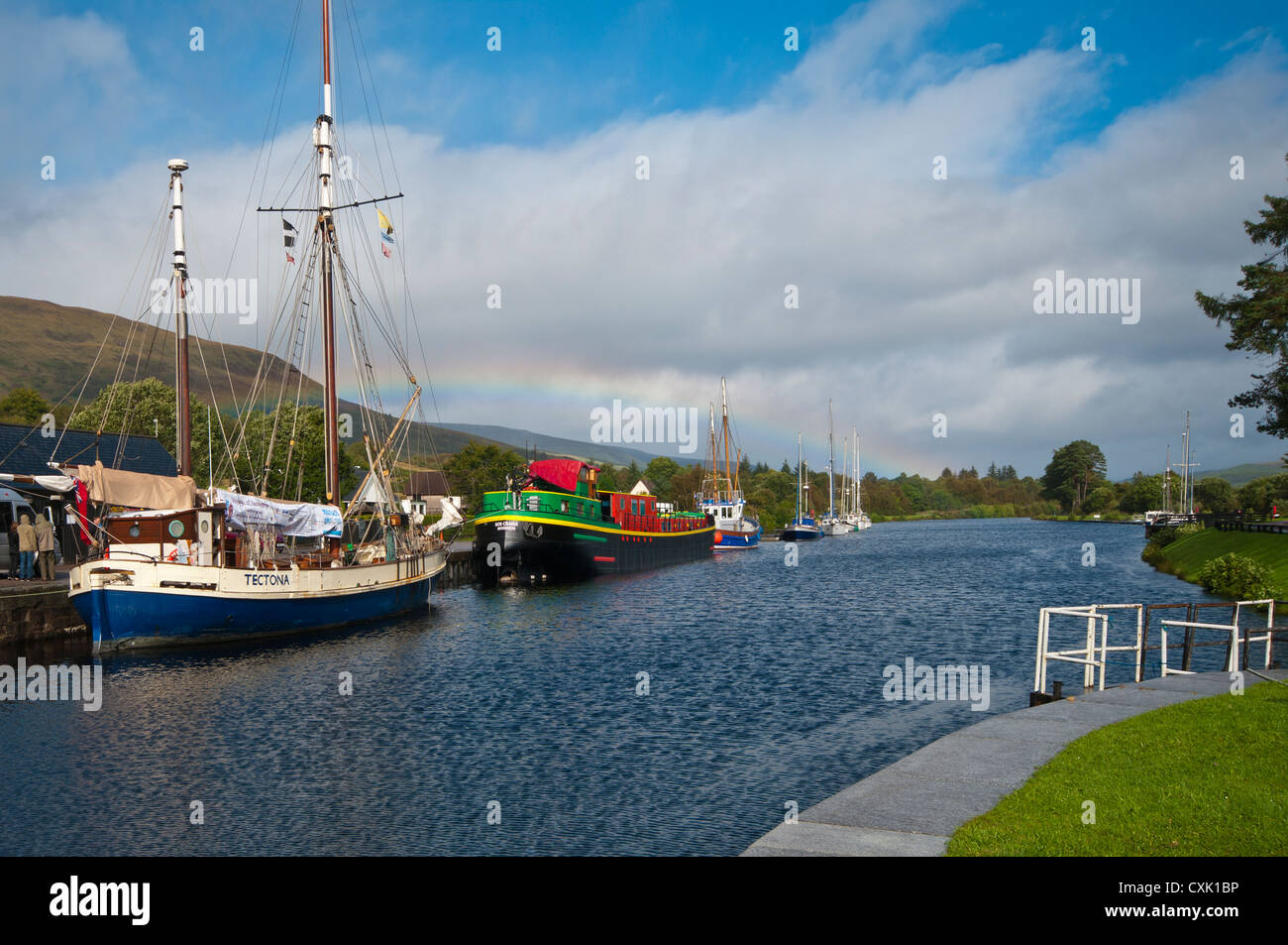Barche ormeggiate sul Caledonian Canal appena sopra Neptunes scalinata Fort William Highland scozzesi con un arcobaleno Foto Stock