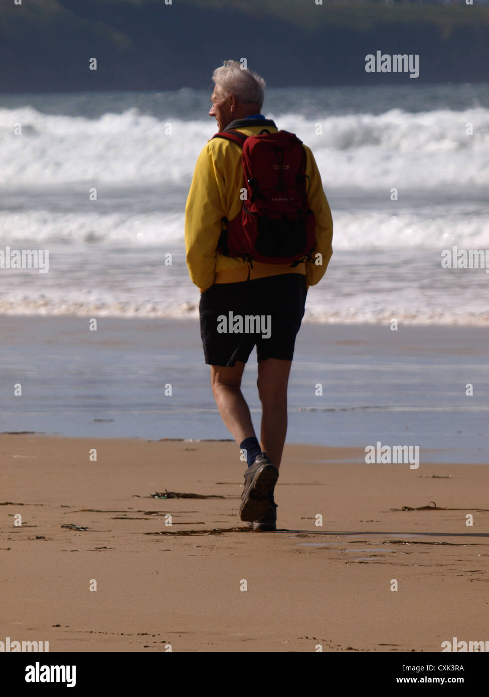 Il vecchio uomo a camminare lungo la spiaggia, Cornwall, Regno Unito Foto Stock