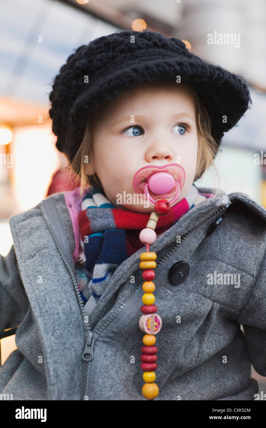 Ritratto di bambina con succhietto indossando Cothes invernale Foto Stock