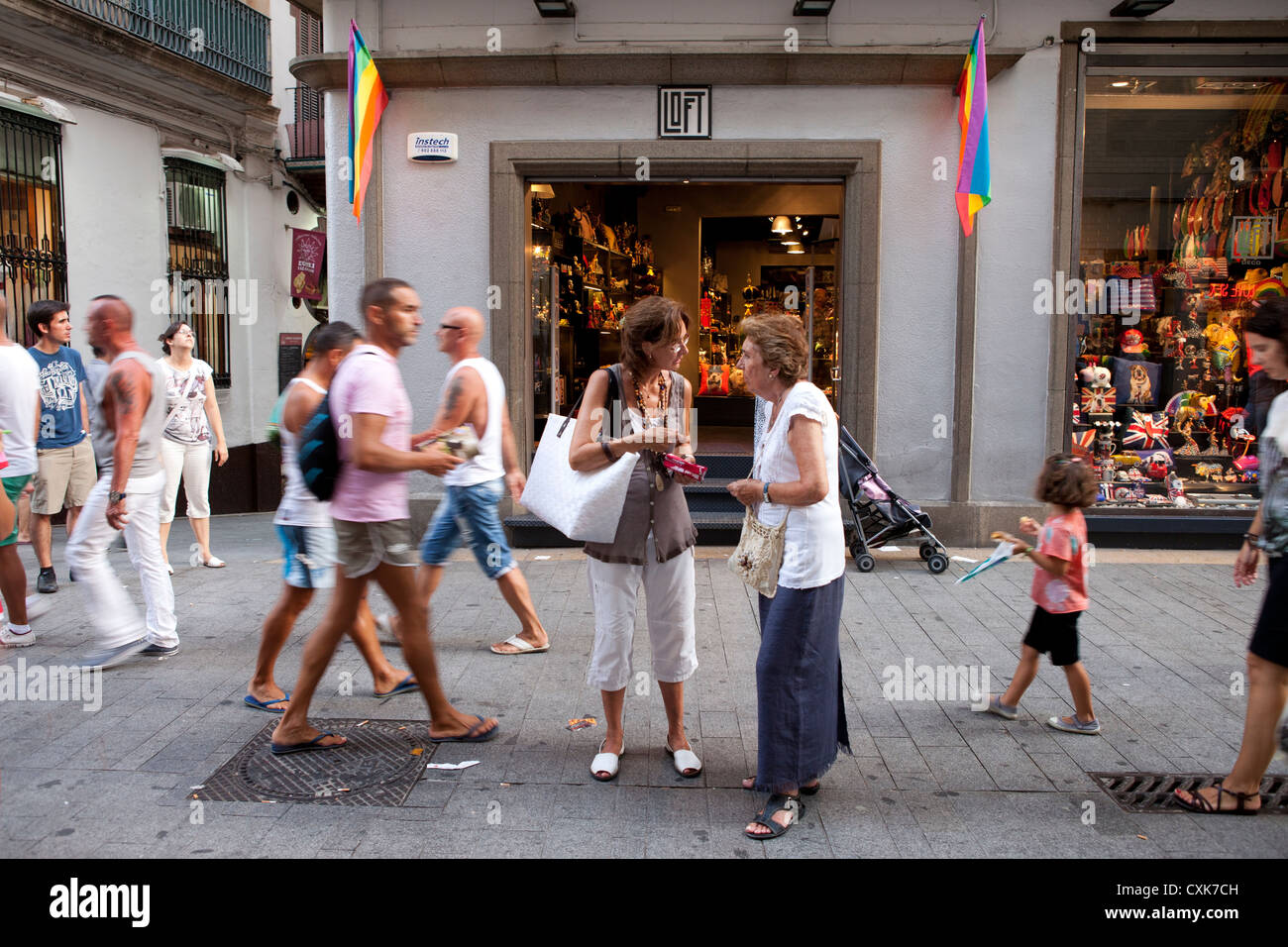 Tre donne fermata a parlare e confrontare gli acquisti al dettaglio su strade trafficate di Sitges, Spagna. Foto Stock