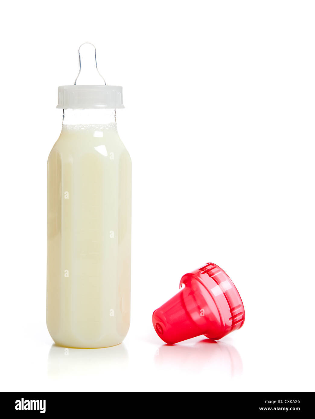 Biberon pieno di latte con un coperchio rosso su sfondo bianco con spazio di copia Foto Stock