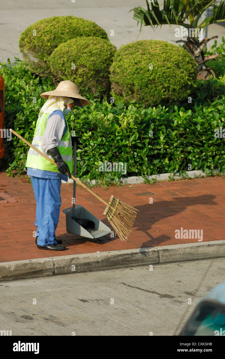 Della città di Hong Kong lavoratore a spazzare le strade. Foto Stock