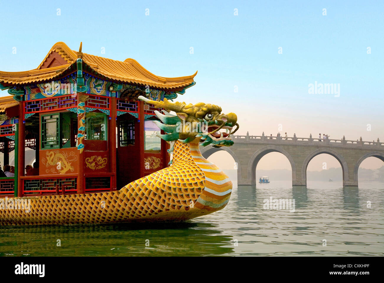 Il palazzo d'Estate a Pechino, Cina, un tradizionale Dragon Boat passa il diciassette il ponte di Arco nel Lago Kunming Foto Stock