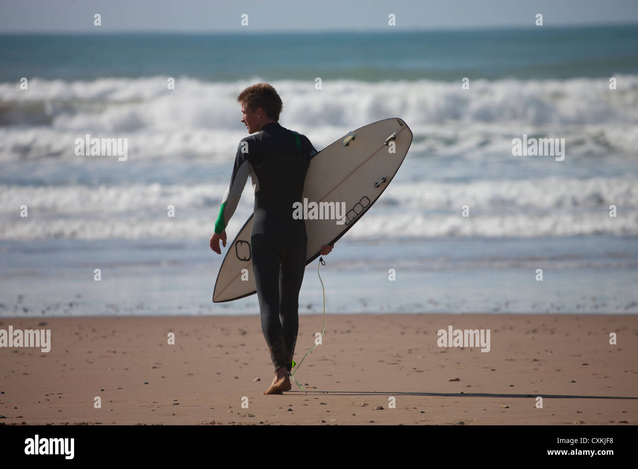 Surfista con la tavola da surf di andare in mare, Marocco Foto Stock