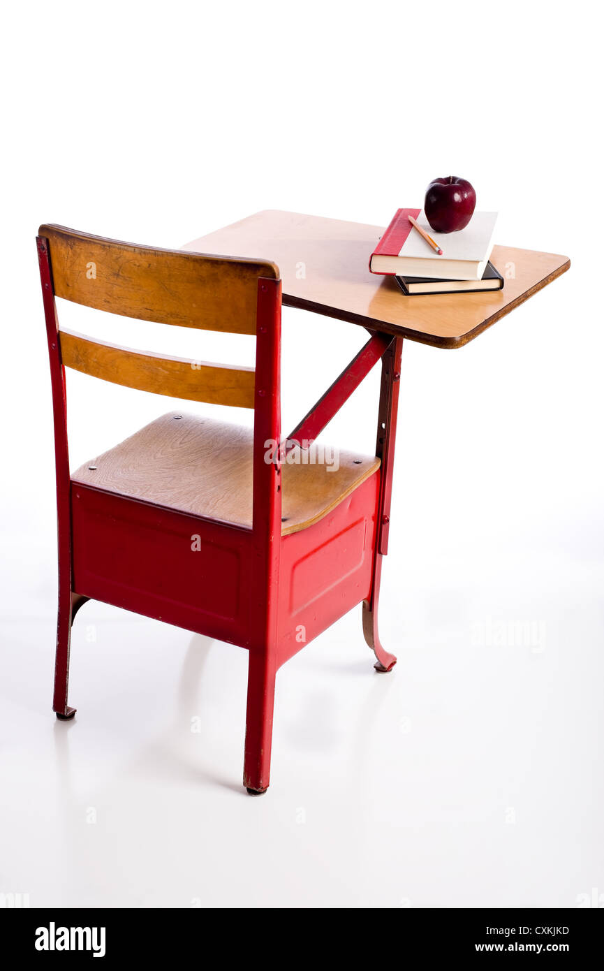 Un rosso, vintage banco di scuola su uno sfondo bianco con libri e un apple con lo spazio di copia Foto Stock