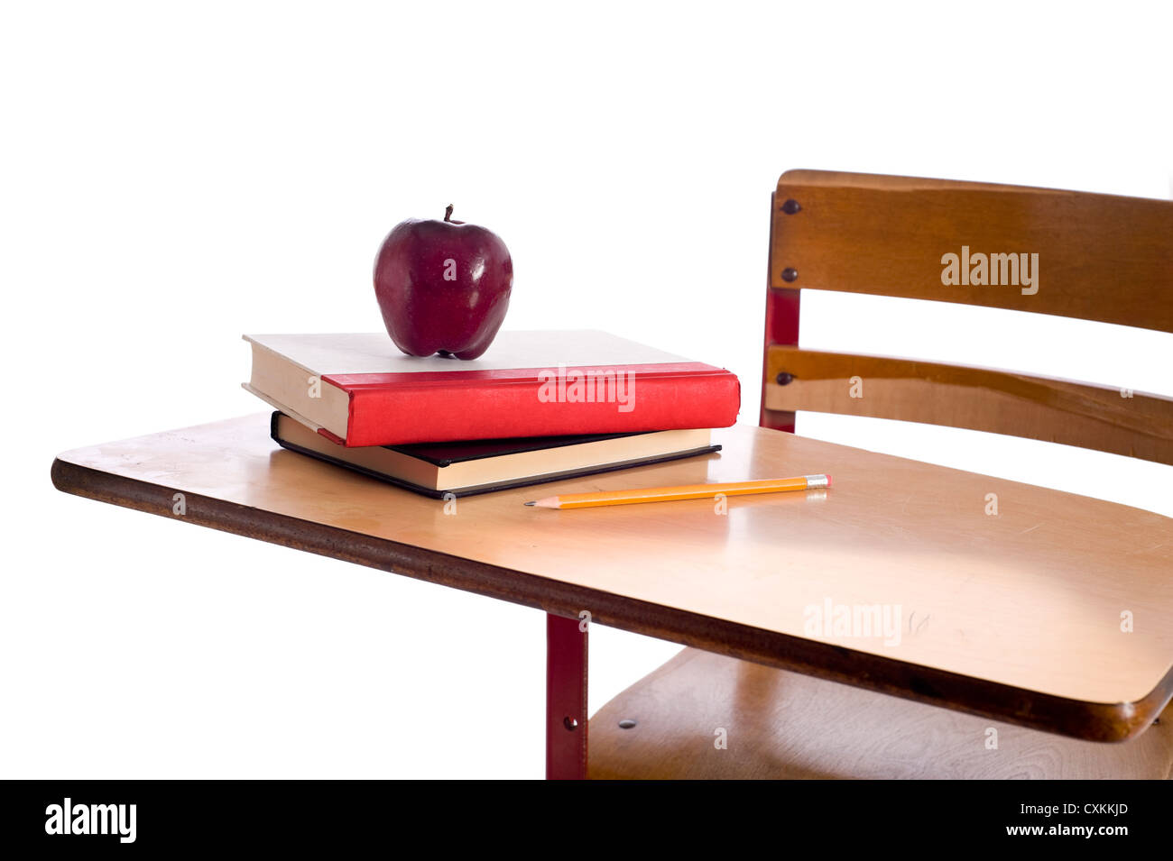 Un vintage banco di scuola con i libri di scuola, una mela rossa e una matita su uno sfondo bianco con spazio di copia Foto Stock