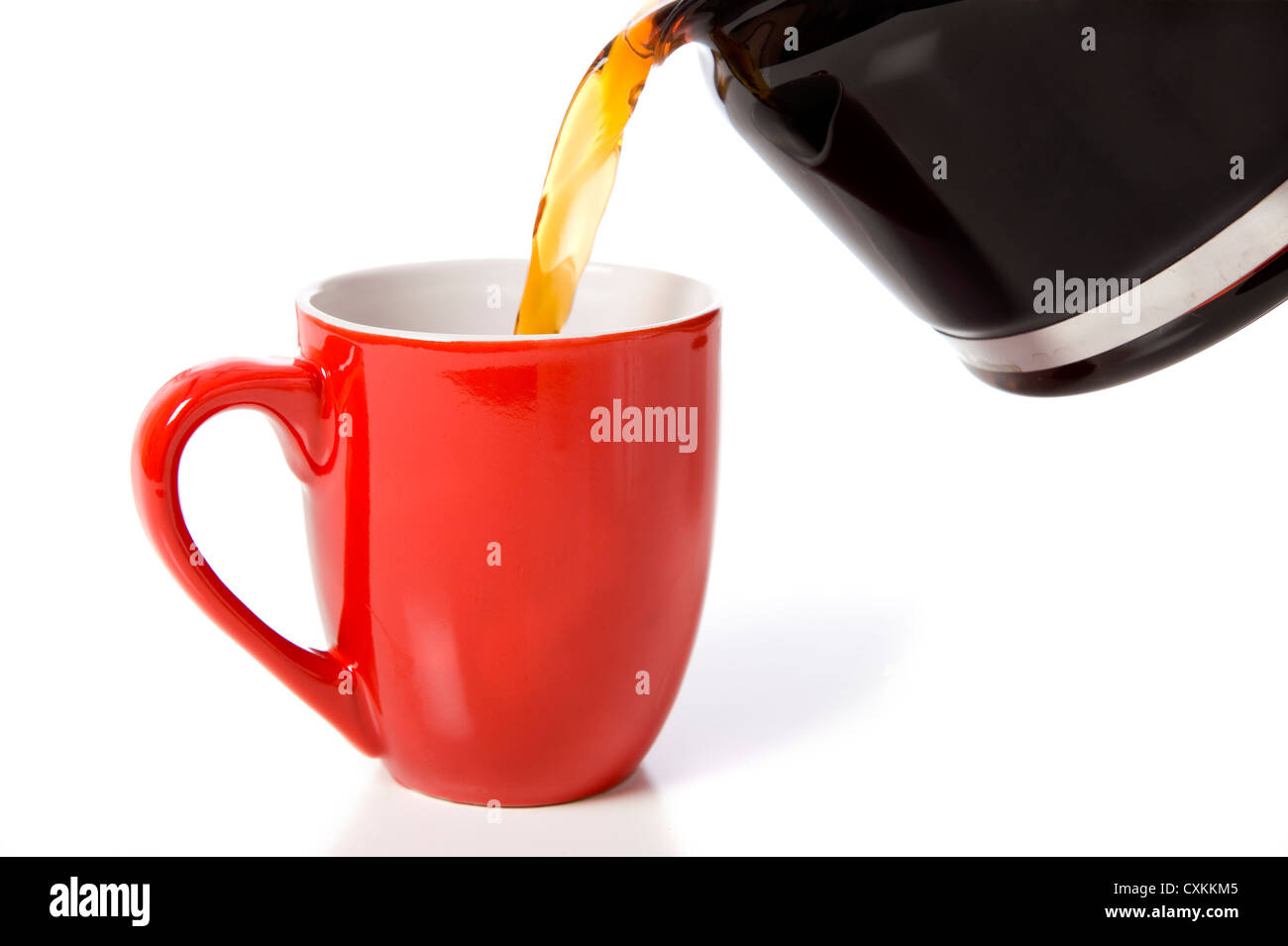 Versando una tazza di caffè in un rosso di cina o tazza di porcellana su uno sfondo bianco con spazio di copia Foto Stock