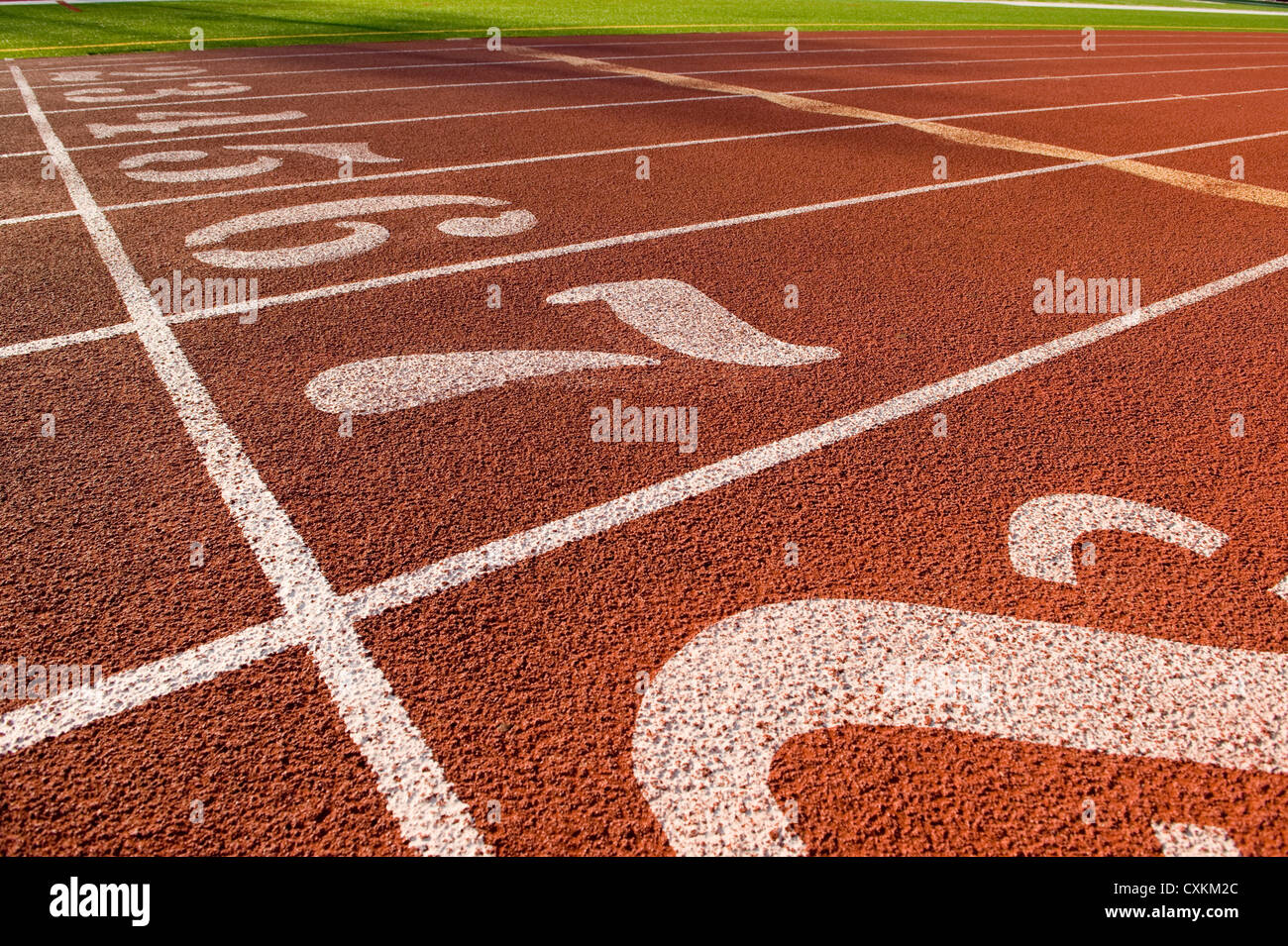 L'esecuzione di marcatori di corsia su una via di corsa la creazione di una pista e lo sfondo del campo Foto Stock