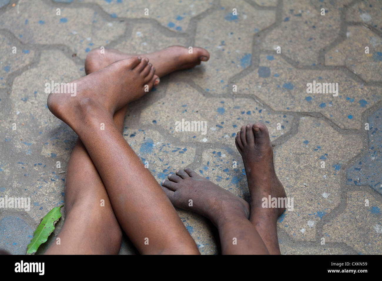I piedi del povero piccolo i bambini che dormono sul marciapiede in Kolkata in India Foto Stock