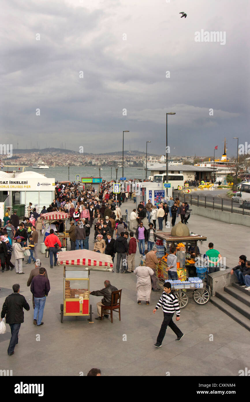 La gente sulla banchina e traghetti, Eminoenue district, Istanbul, Turchia, Europa Foto Stock