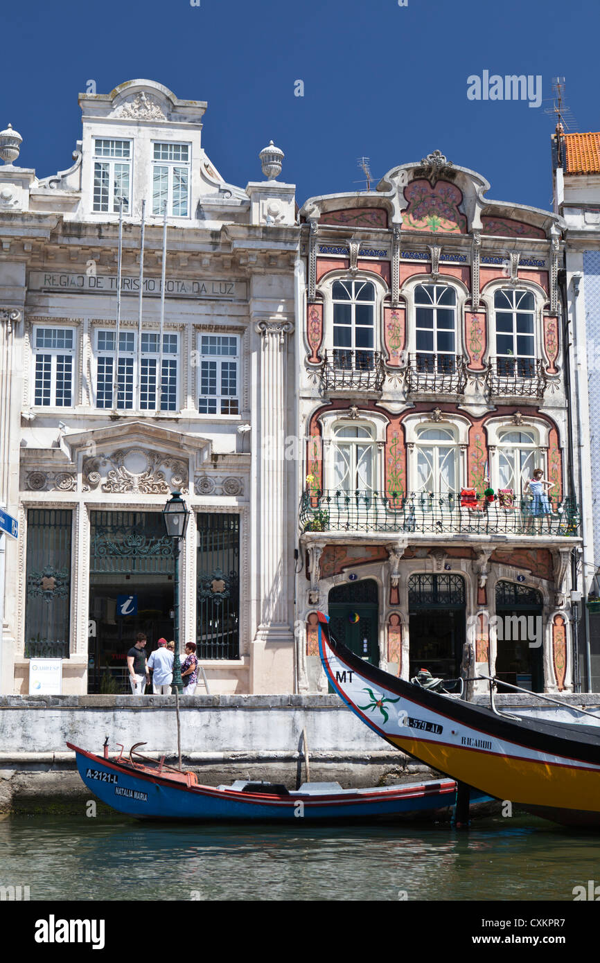 Edifici art nouveau e la prows della tradizionale moliceiros barche ormeggiate sul canale di Aveiro, Portogallo Foto Stock