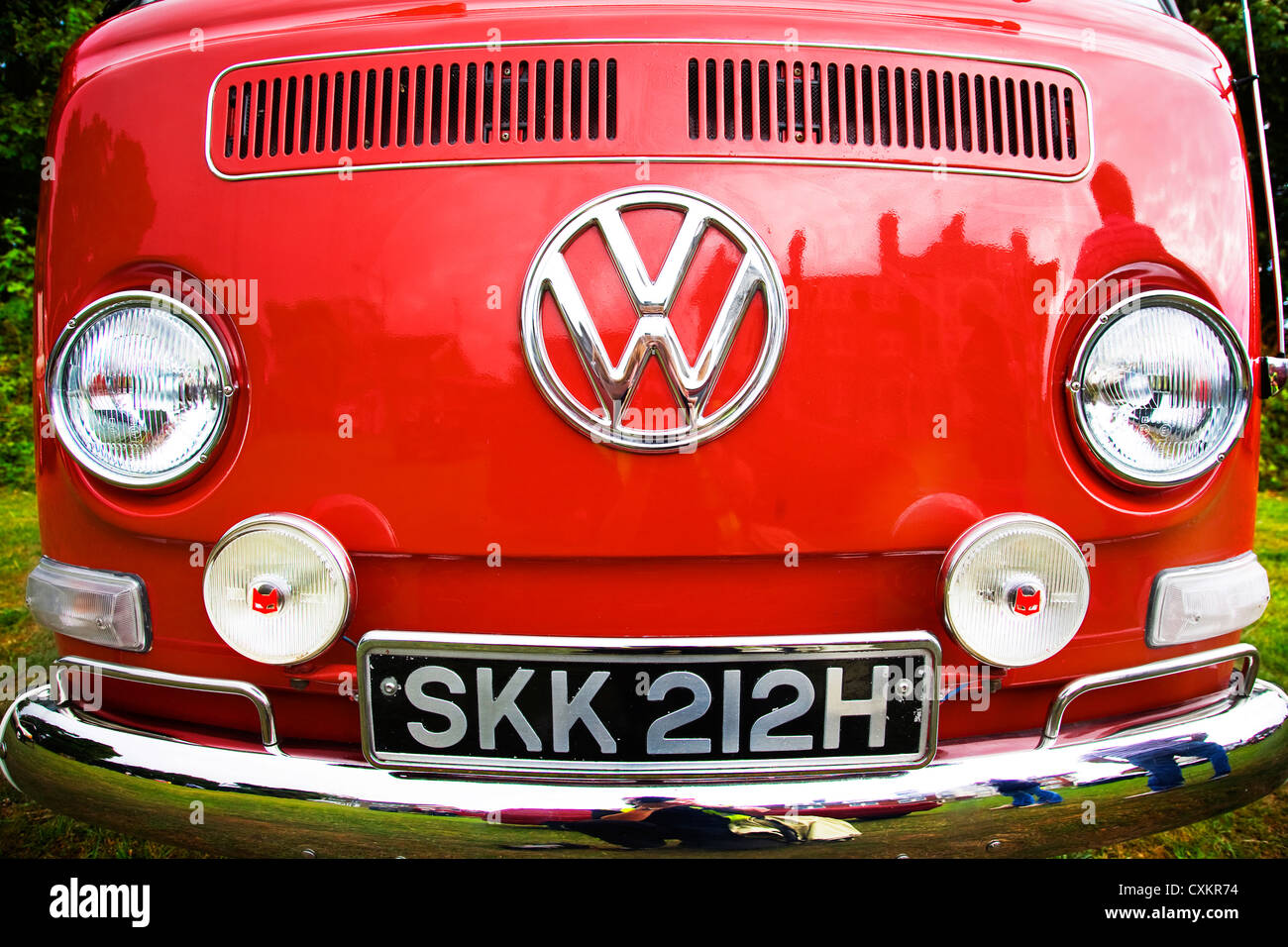 Vista frontale del rosso vintage VW camper parcheggiato su erba Foto Stock