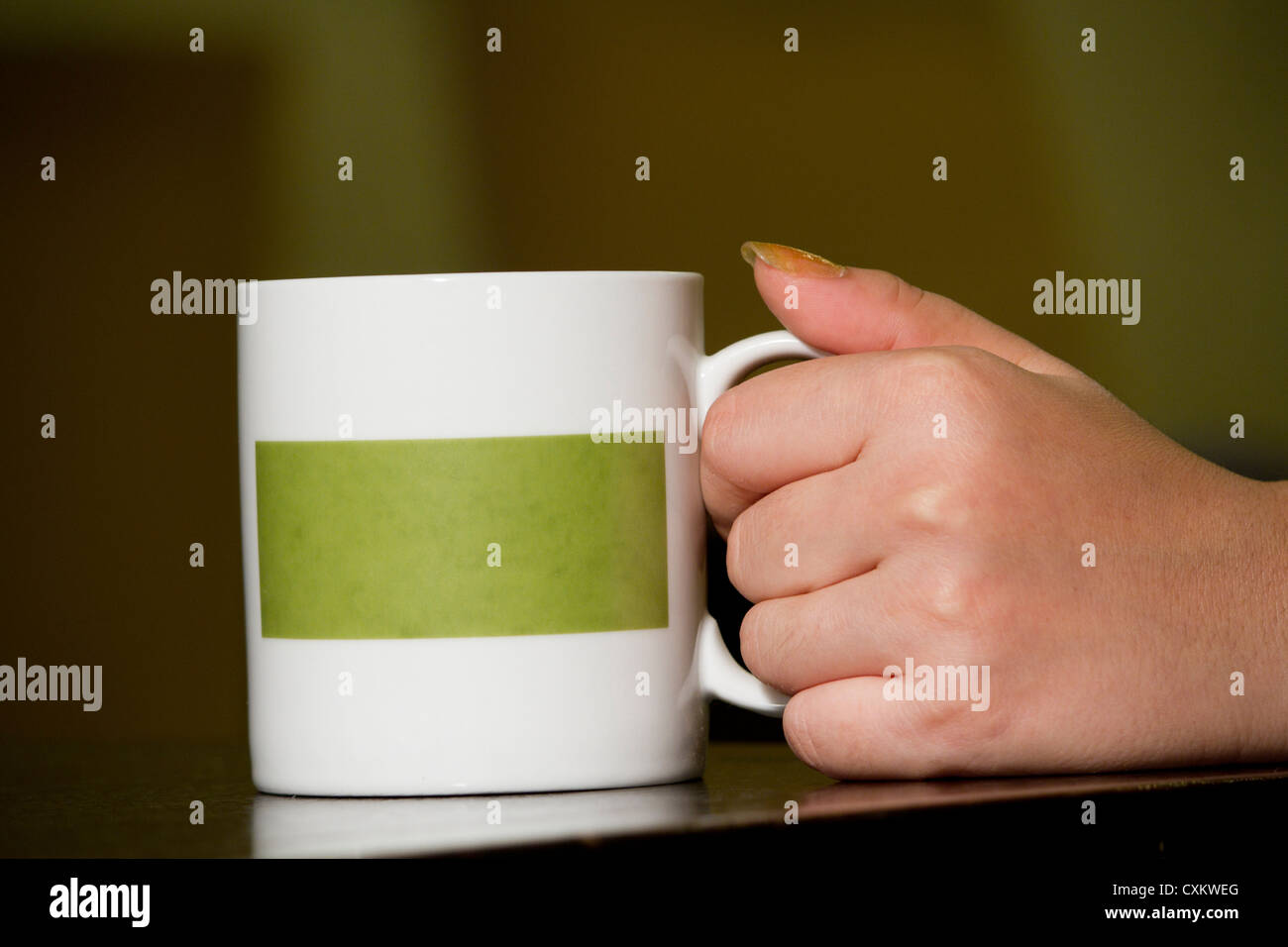 Le donne a mano prendere tazza bianca cinghia di caffè verde Foto Stock