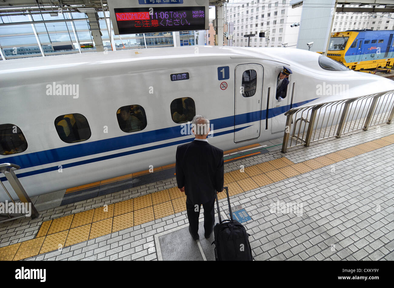 Un passeggero che attende per le porte di un treno bullet per aprire. Foto Stock