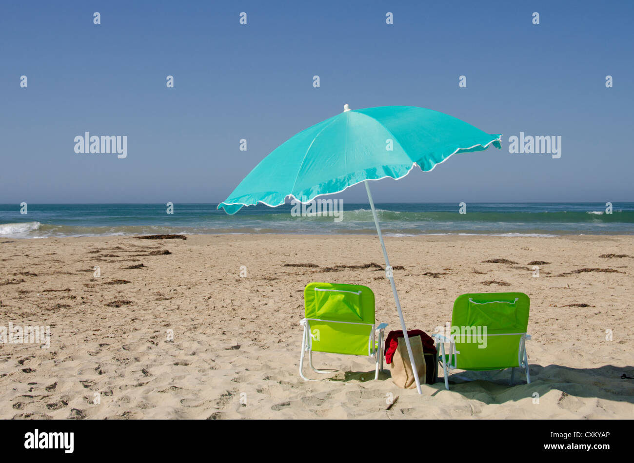 California, Pacific Coast, Pismo Beach. Ombrellone e sedie vuote sul Pismo State Beach. Foto Stock