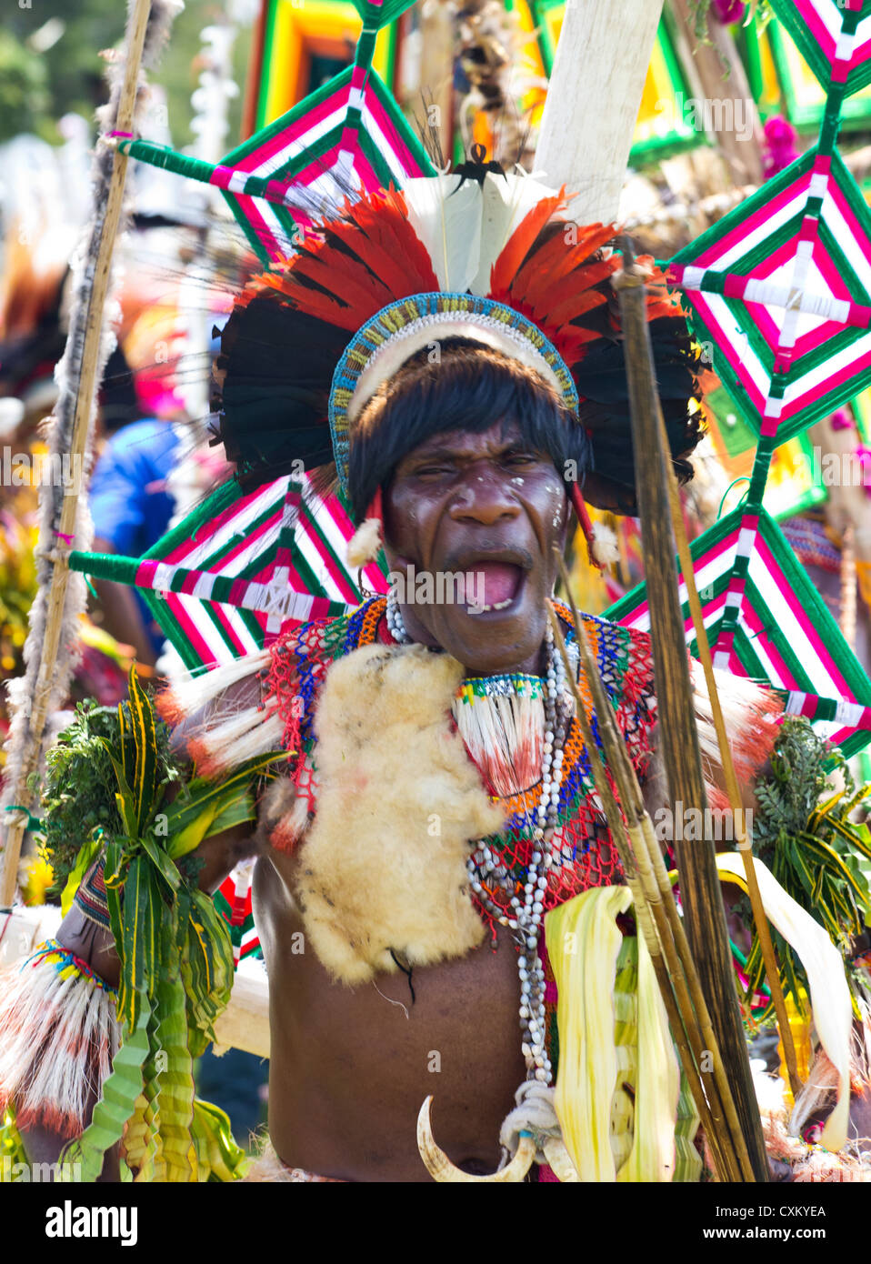L'uomo con il suo volto dipinto e indossando il tradizionale costume tribali al singsing Festival Goroka, Papua Nuova Guinea Foto Stock