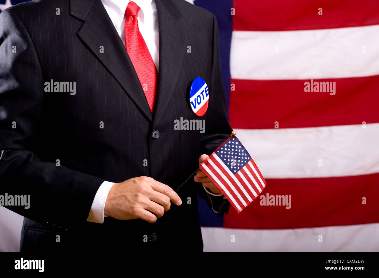 Un uomo che indossa un blu business suit e legare con un pulsante di votazione. Il giorno delle elezioni in background o di concetto Foto Stock