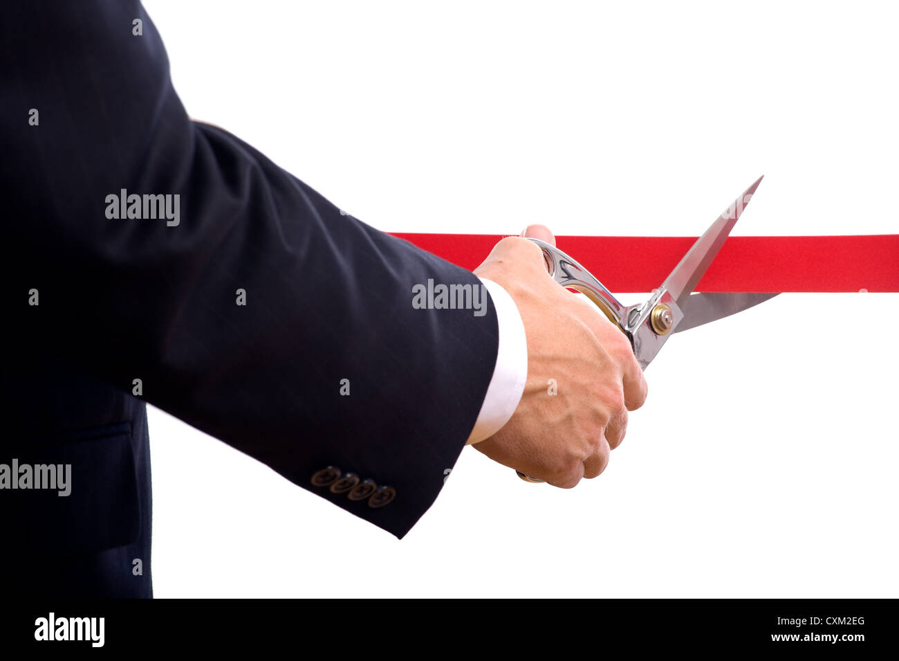 Un uomo di affari che indossa una tuta blu il taglio di un nastro rosso con una coppia di argento lucido forbici. Grand cerimonia di apertura o un evento Foto Stock