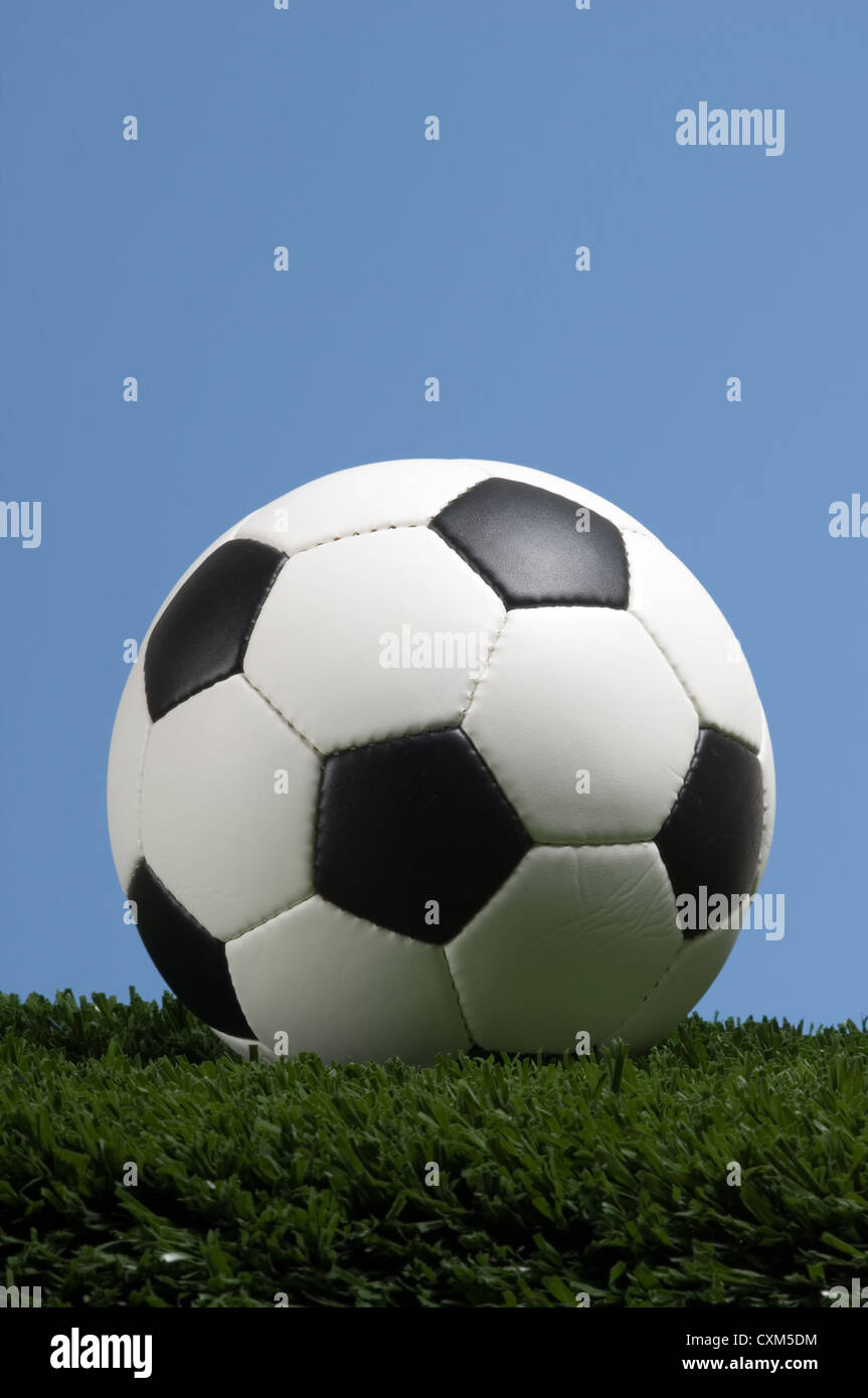 Calcio, pallone da calcio in erba con un luminoso cielo blu Foto Stock