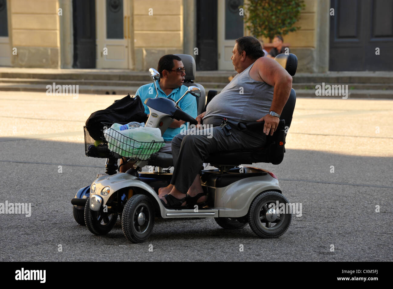 Due persone sulla disabilità scooter a Lucca in Toscana Foto Stock