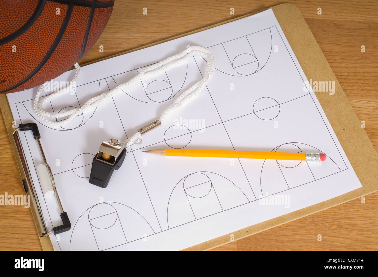Un pullman di pallacanestro di elementi tra cui un fischio e una clipboard con diagrammi di corte e una matita Foto Stock