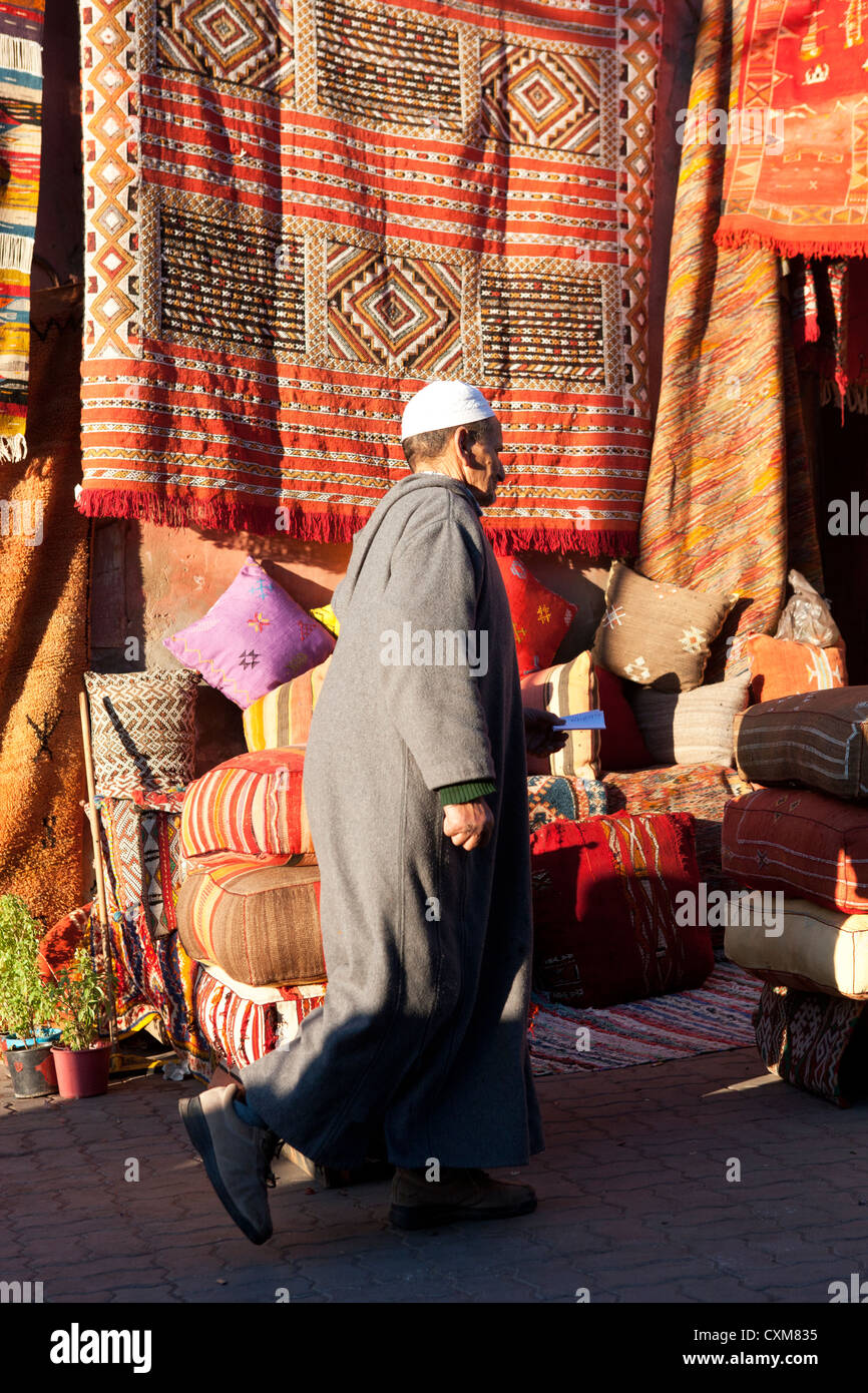 Uomo marocchino dal negozio di tappeti, tappeti, cuscini e piumini, Marrakech, Marocco Foto Stock