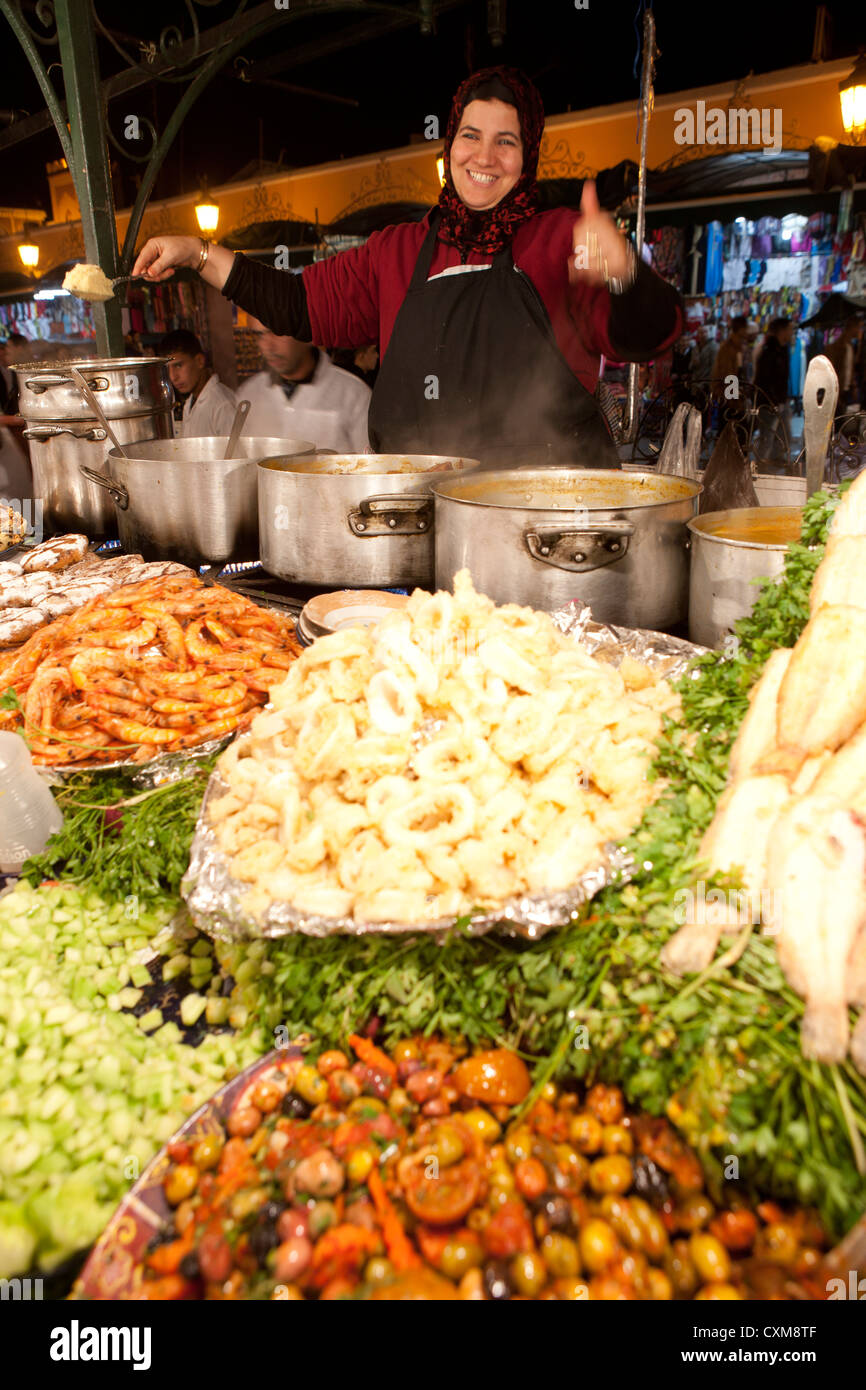 Piazza Jamaa El Fna a Marrakech, Marocco donna locale di bancarelle di cibo poco costoso mangiare a buon mercato Medina Foto Stock