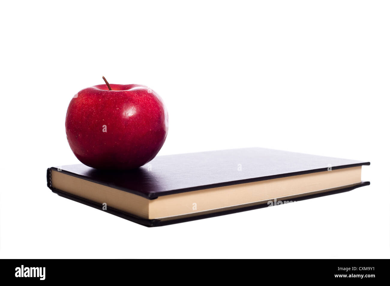 Una scuola nera libro e una mela rossa su uno sfondo bianco con spazio di copia Foto Stock