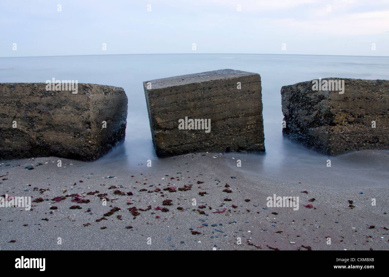 Gli interruttori di onda in mare, cubica calcestruzzo alla spiaggia Foto Stock