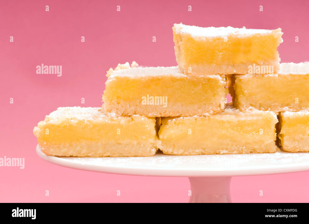 Deliziosi appena sfornato piazze di limone su una torta bianca stand Foto Stock