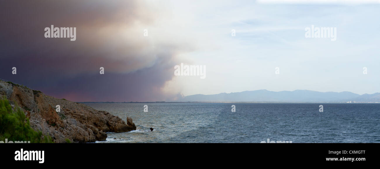 Forrest fire in Spagna fa un drammatico cielo sopra una baia sulla costa brava Foto Stock