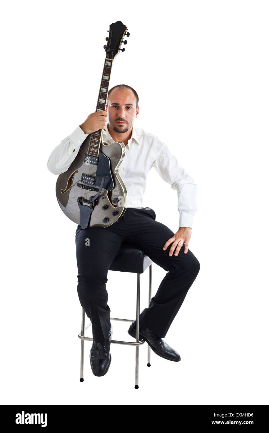 Un ben vestito musicista jazz seduto su uno sgabello e tenendo una chitarra  Foto stock - Alamy