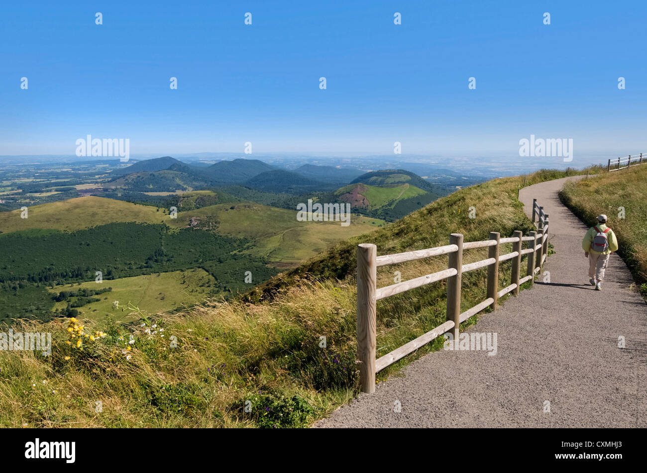 Escursionista con vista dal Puy de Dome sul paesaggio vulcanico della Chaine des Puys, Massiccio centrale, Auvergne Francia, Europa Foto Stock