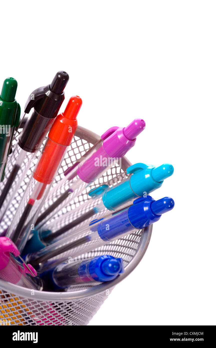 Uno sfondo della scrivania porta penna piena di colorati luminosamente penne su uno sfondo bianco con spazio di copia Foto Stock