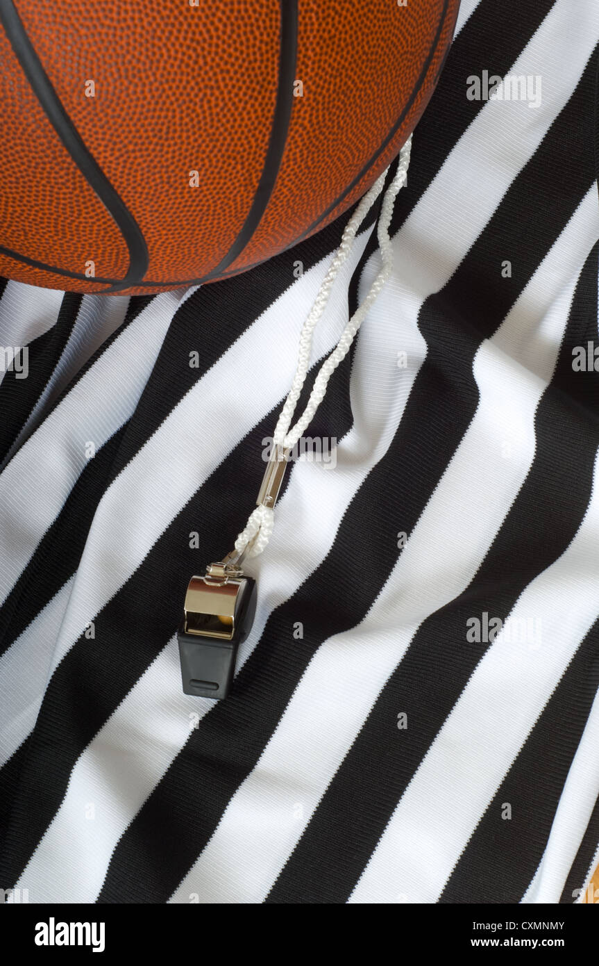 Un arbitro jersey con un fischio e una palla da basket, basket arbitro attrezzature Foto Stock