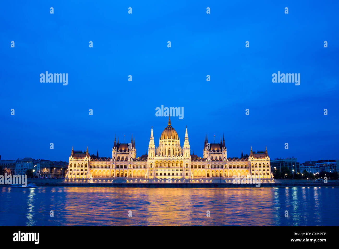 Budapest il palazzo del parlamento in Ungheria al crepuscolo, riflessioni sul fiume Danubio acque. Foto Stock