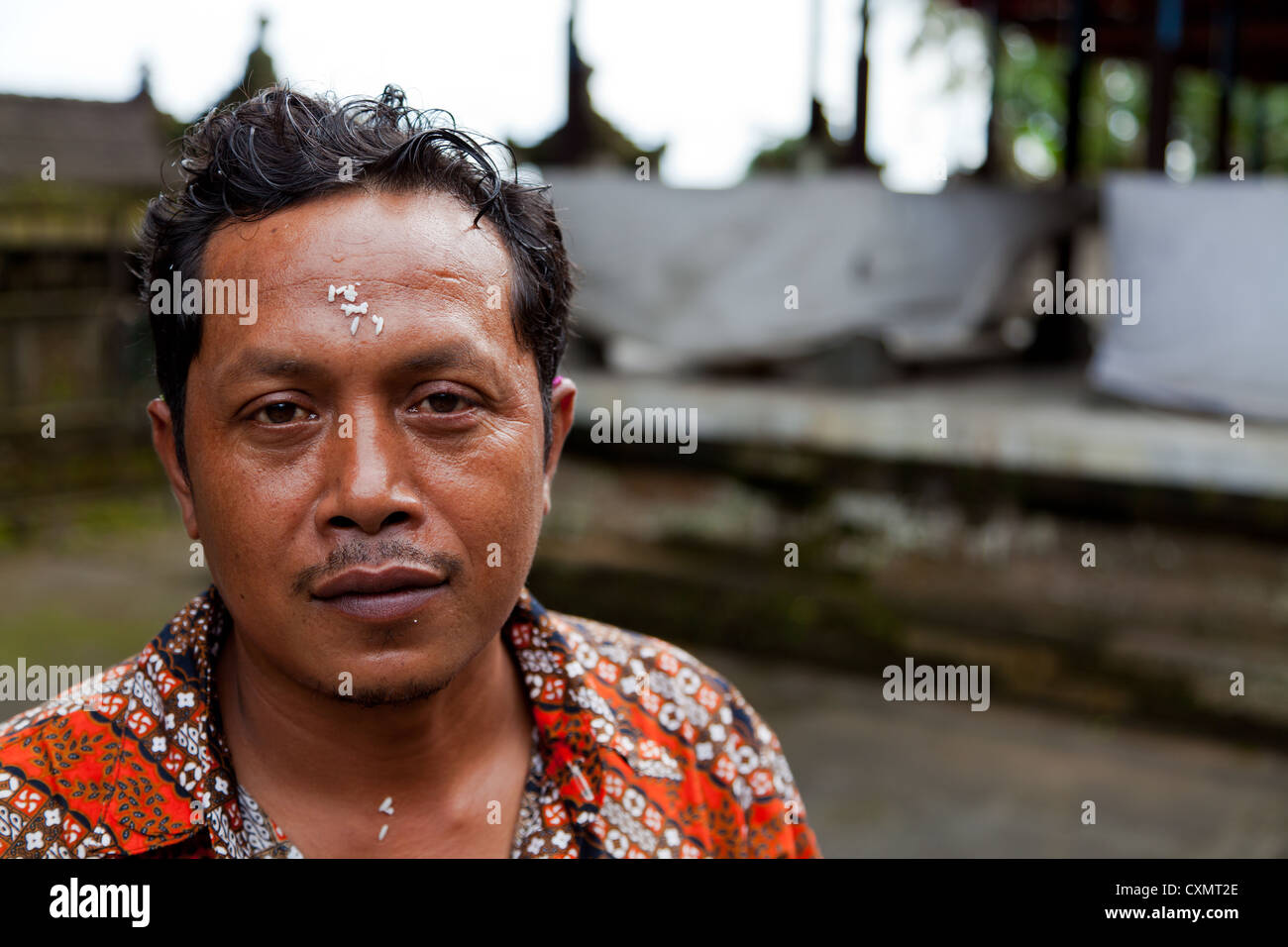 Uomo Balinese con riso i calli sulla sua parte anteriore su Bali Foto Stock