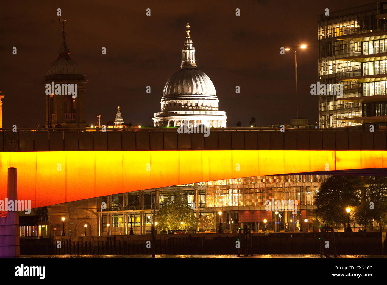 La Cattedrale di San Paolo sorge dietro un illuminato London Bridge, oltre il Fiume Tamigi di notte, Central London, England, Regno Unito Foto Stock