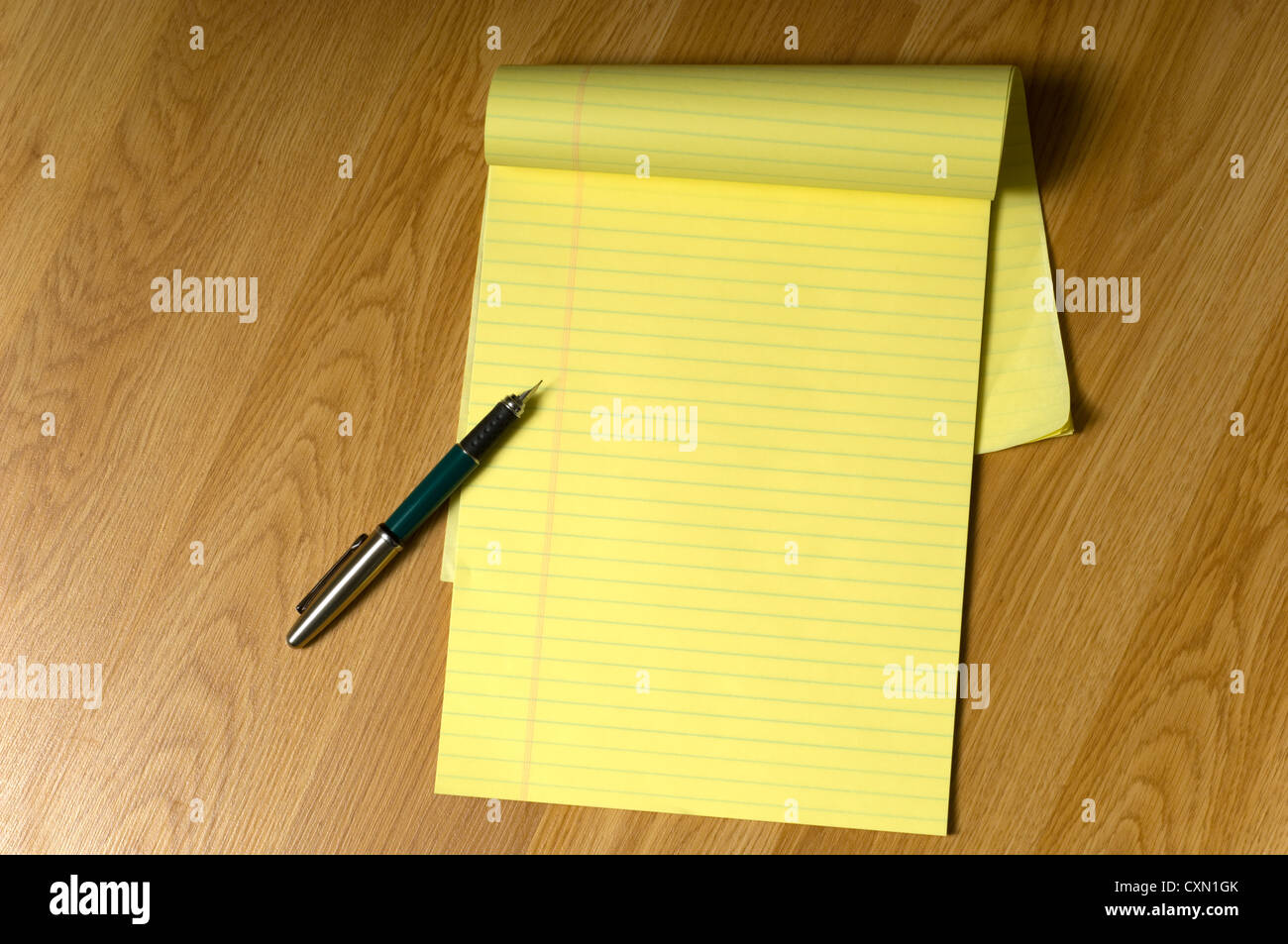 Un vuoto giuridico giallo pad su un marrone scrivania in legno o piano con una penna per scrivere sul bordo, aggiungi la tua copia Foto Stock