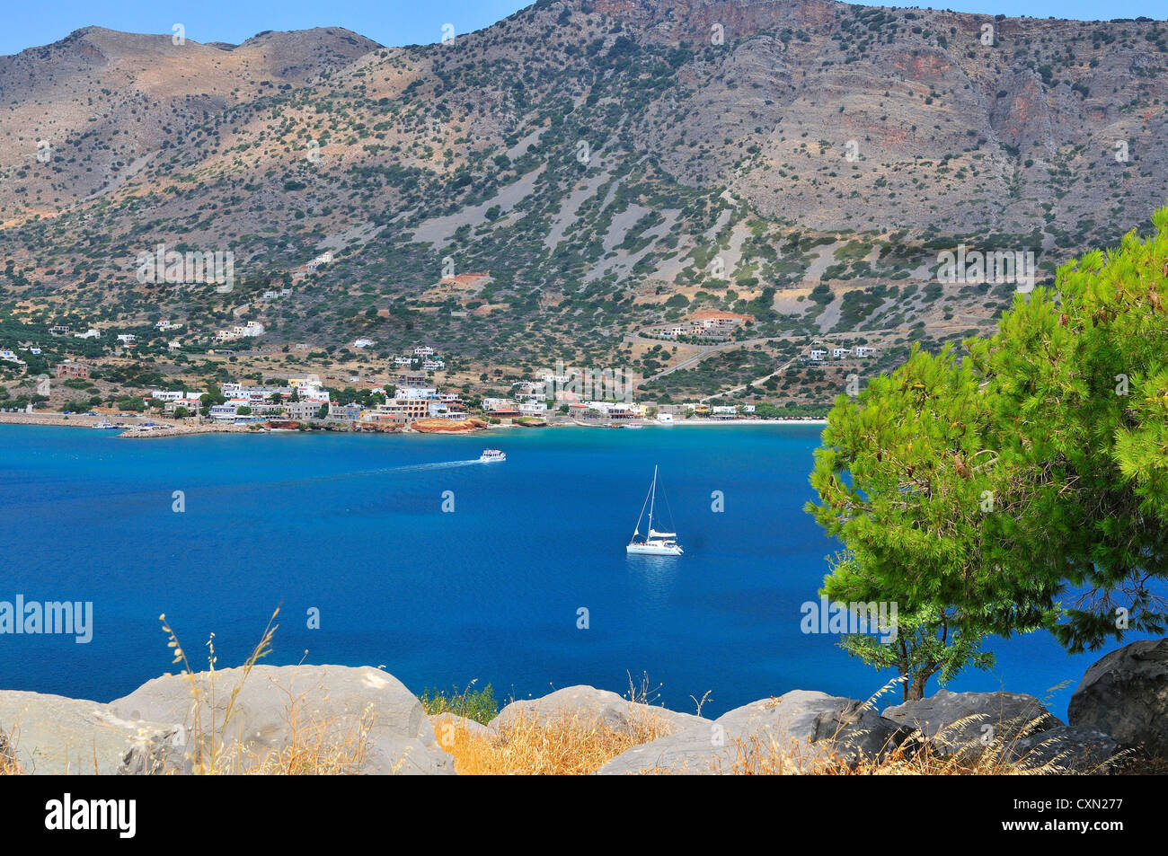 Vista di un caicco che torna turisti da Spinalonga alla Plaka continentale. Spinalonga era precedentemente usato come colonia di lebbrosi. Creta, Grecia Foto Stock