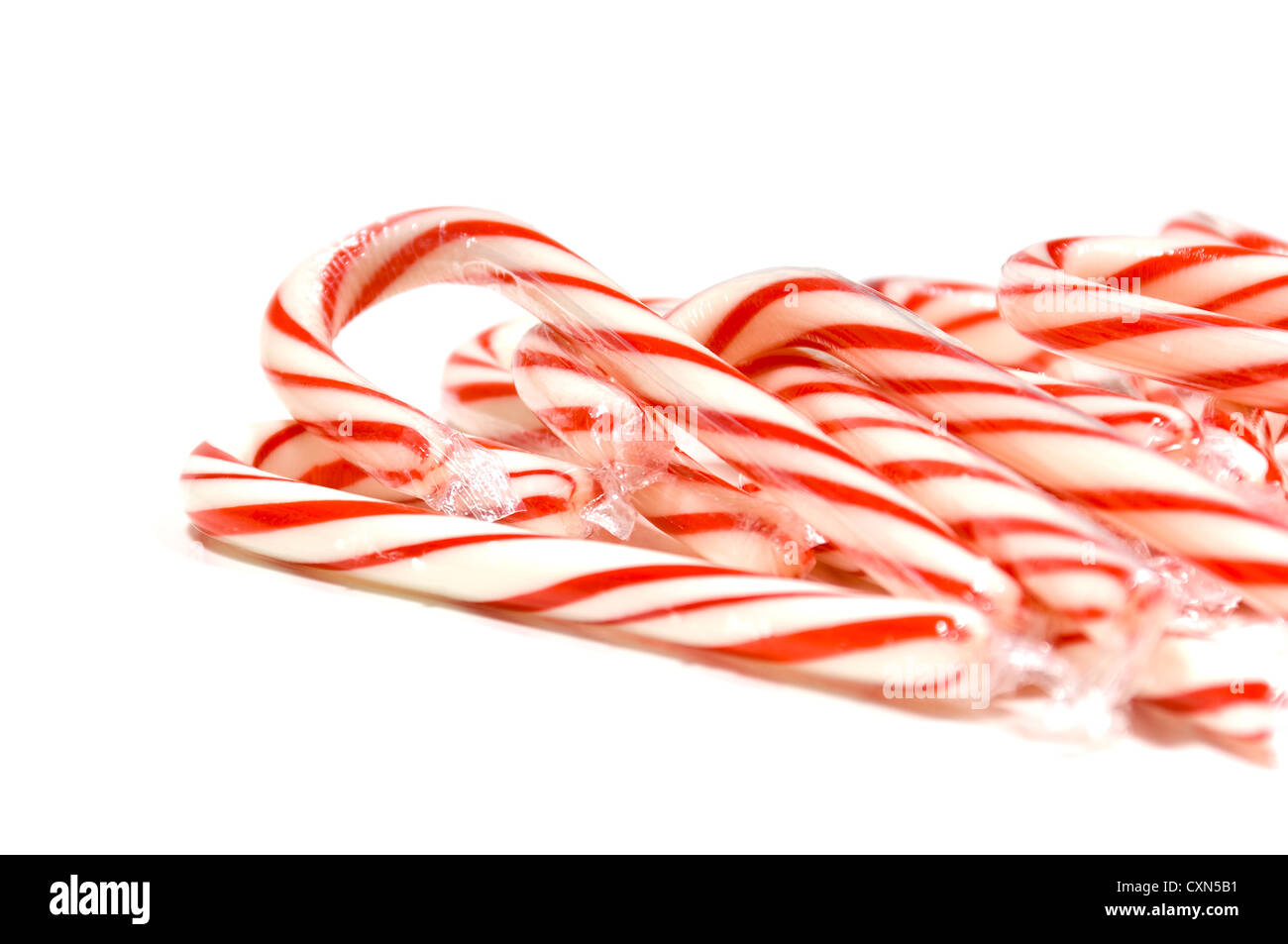 Pila del rosso e del bianco candy canes su sfondo bianco- caramella di Natale Foto Stock