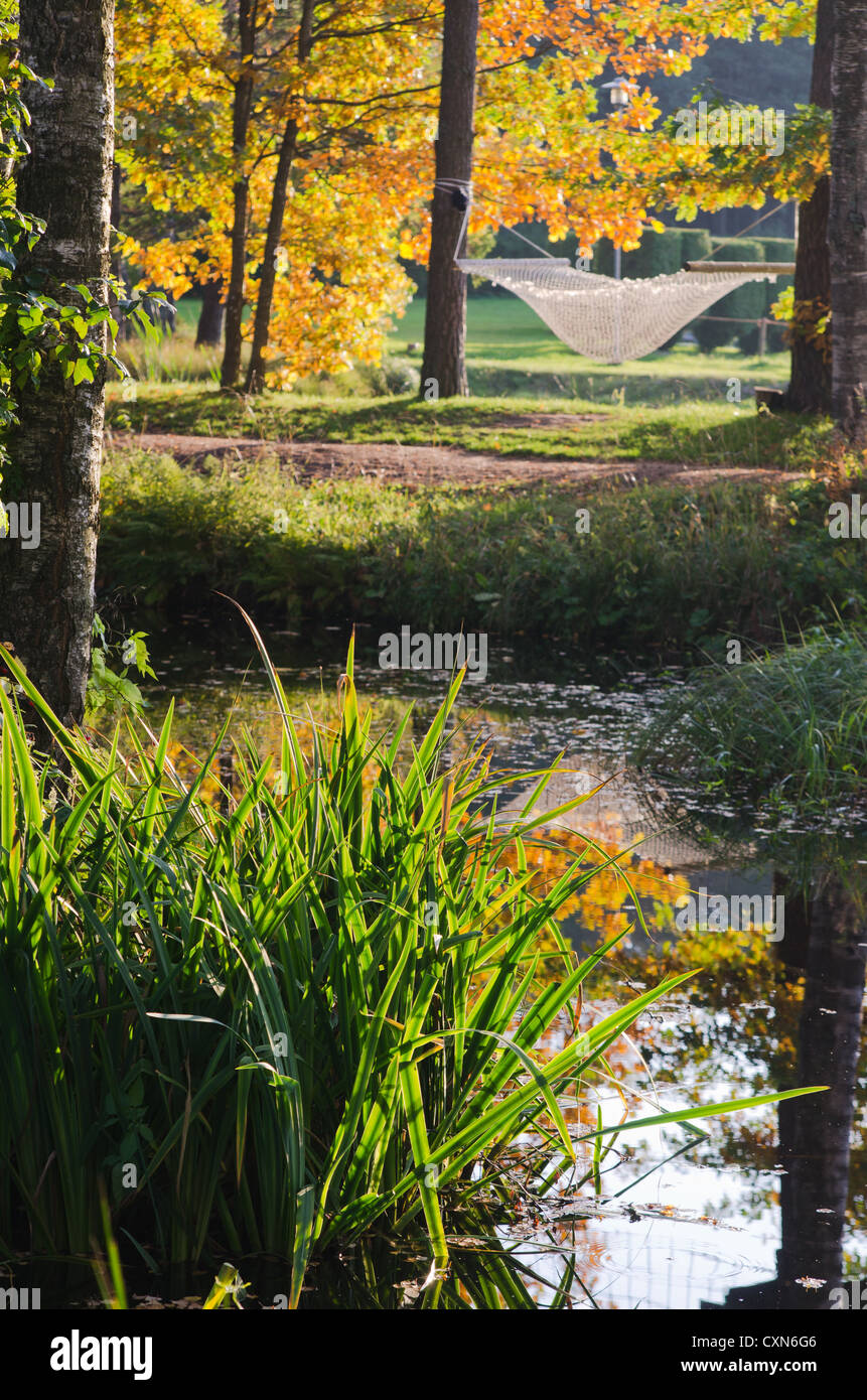 Un amaca vicino al laghetto nel Parco di autunno Foto Stock