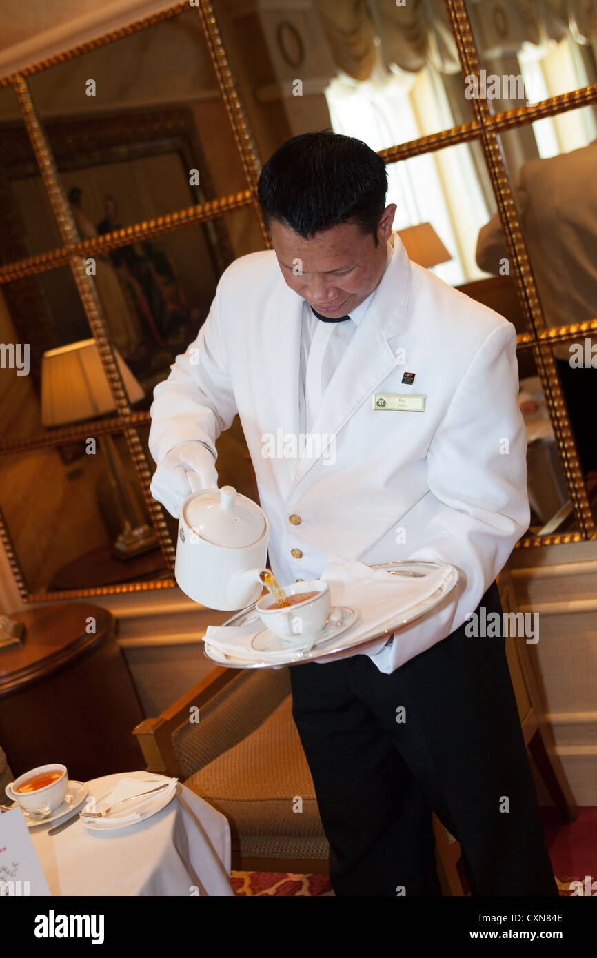 Gustando il tè del pomeriggio. Servire il tè del pomeriggio nel Queens Room. Cunard Liner "Queen Victoria" in mare. Steward versando una tazza di tè. Foto Stock