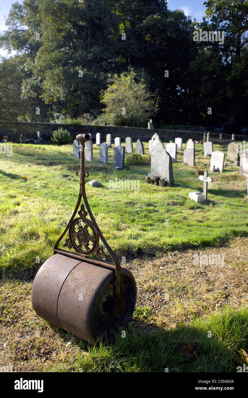 Il vecchio rullo da giardino nel cimitero della Chiesa di San Pietro Hambledon Surrey in Inghilterra UK GB Inghilterra rurale Inglese Gran Bretagna Foto Stock