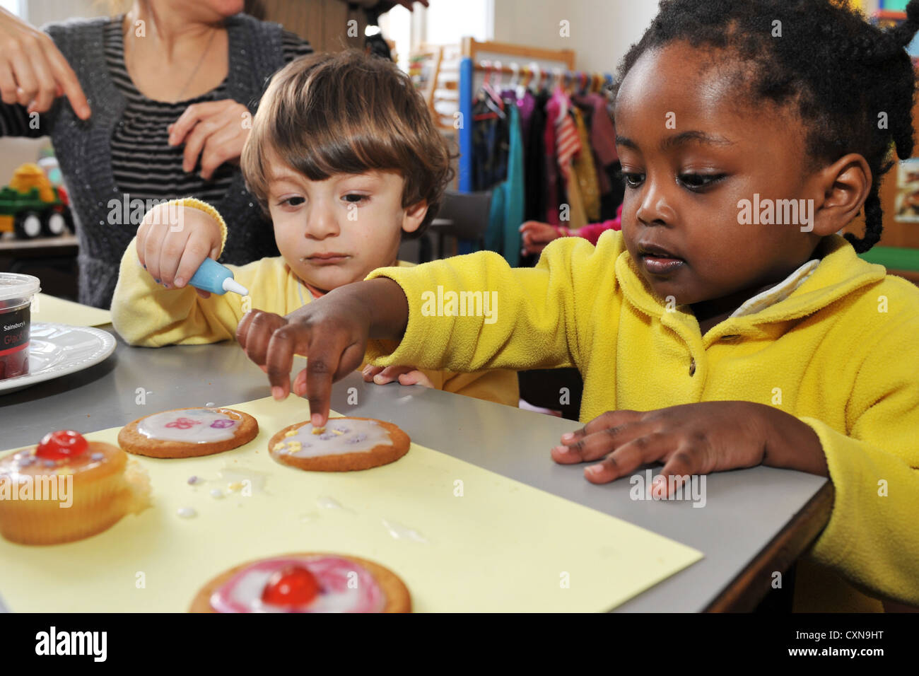 I bambini fanno iced biscotti per il sollievo comico Foto Stock
